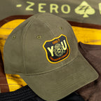 Only You Cap olive green baseball hat with curved brim and embroidered black and yellow front patch displayed on a wooden surface