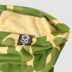 Close-up of a green and yellow camo patterned Performance Sun Gaiter featuring a small tag with a skull and spade logo, highlighting the fabric texture and stitching.