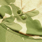 Close-up of the green and beige camouflage fabric with snap button details on the Performance Sun Hoodie.