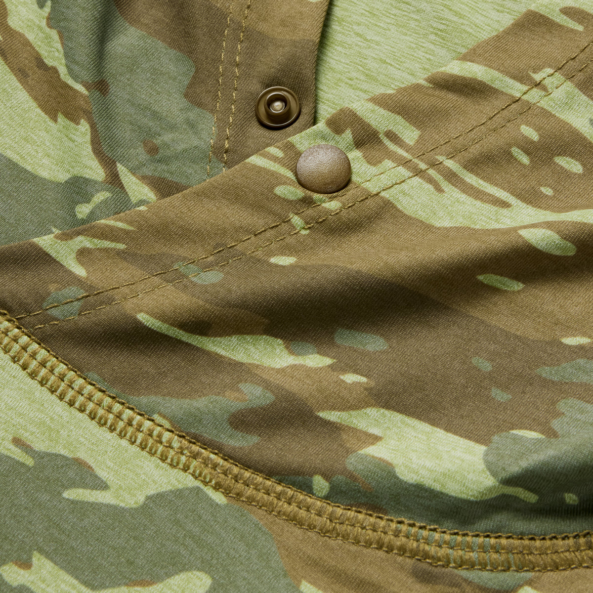 Close-up of a camouflage fabric detail with stitching and snap buttons on the Performance Sun Hoodie, highlighting its durable and breathable material.