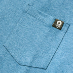 Close-up of an ocean blue Performance Sun Hoodie showing a textured fabric pocket with a small black tag featuring a white logo, highlighting the material and stitching detail.
