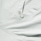 Close-up detail of light gray fabric with stitching and snap button of the Performance Sun Hoodie, highlighting its smooth texture and durable construction.