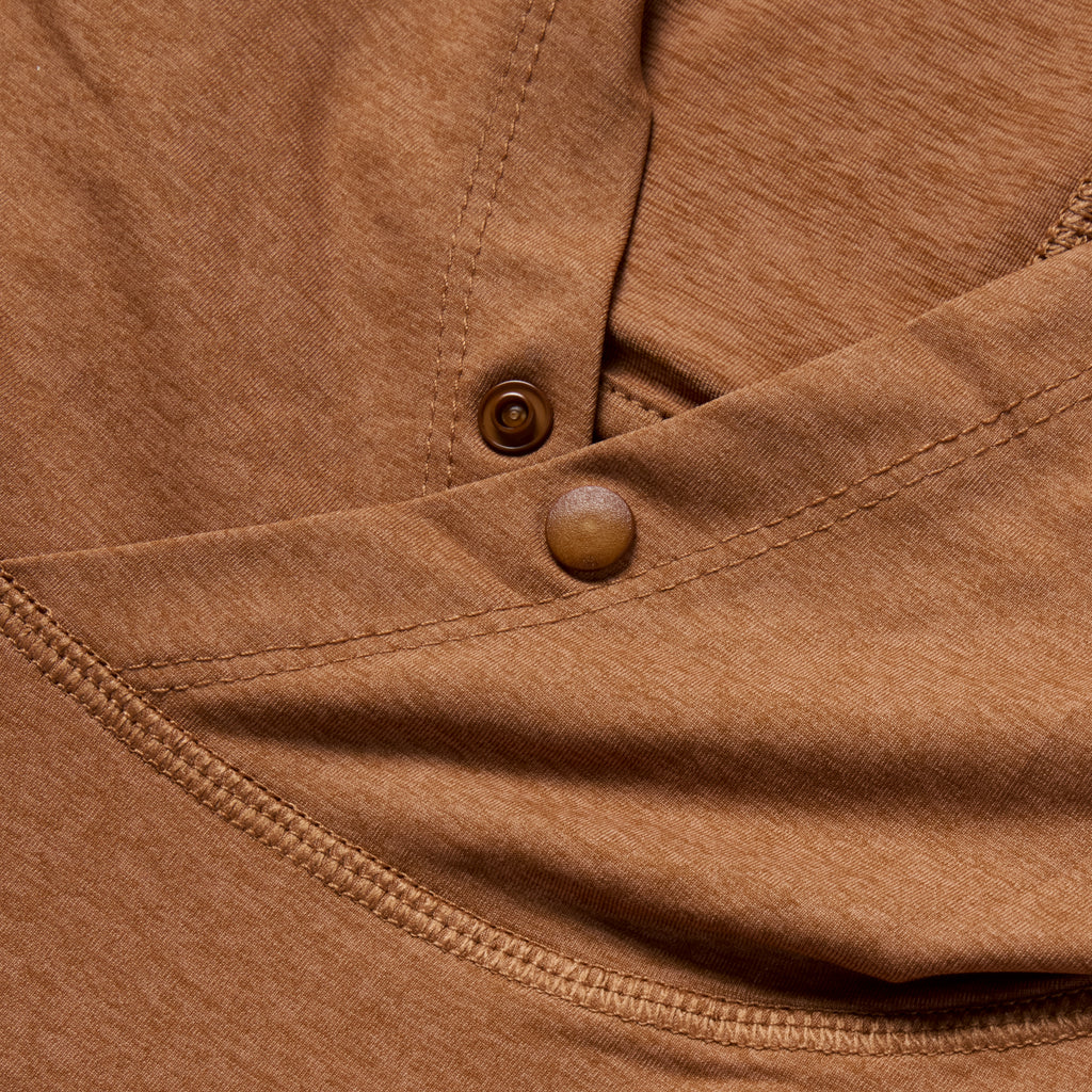 Close-up of the rust-colored Performance Sun Hoodie fabric showing detailed stitching and button snaps on the hood.