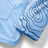 Close-up of light blue fabric with topographic line patterns on the sleeve and mesh texture on the body of the Crew Rash Guard (Last Season) shirt.