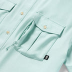 Close-up of a light aqua fabric pocket with a flap and button detail on the Short Sleeve F'n Soft Shirt, highlighting its soft texture and functional design.