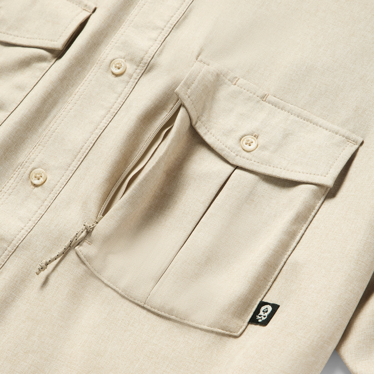 Close-up of tan fabric and detailed front pockets with button closures on the Short Sleeve F'n Soft Shirt, highlighting its soft texture and sturdy design.
