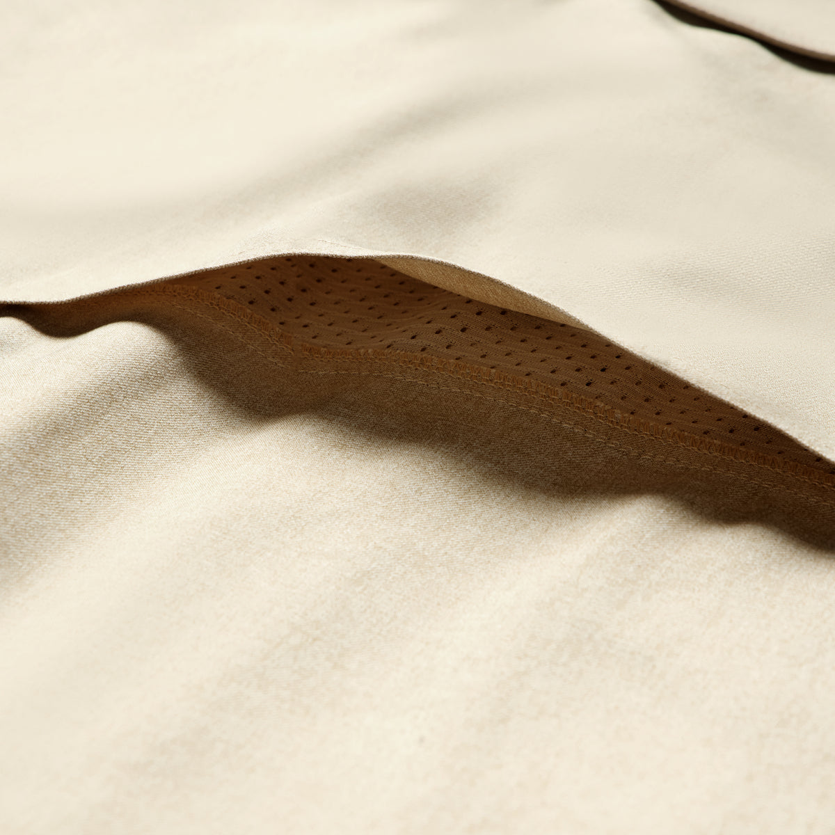 Close-up of tan-colored fabric with perforated detailing on the inner layer, highlighting the soft texture and breathability of the Short Sleeve F'n Soft Shirt.