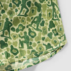 Close-up of fabric with a camouflage pattern featuring green Army Men silhouettes in various poses on a light green background, part of the Army Men Silkies clothing.