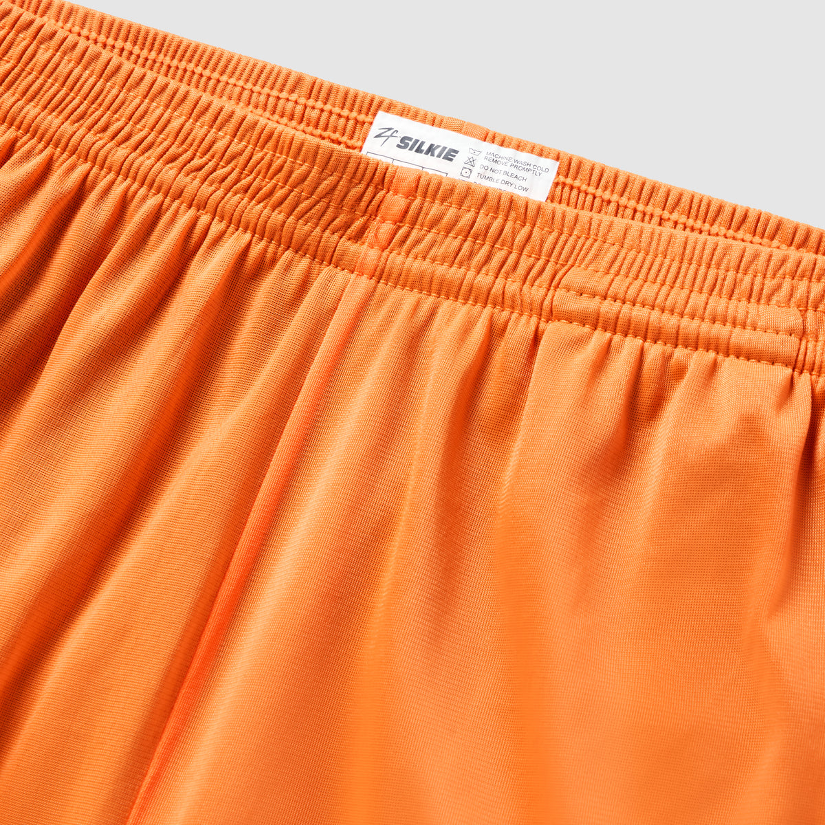 ZF Silkies - Solids in vibrant orange with a gathered elastic waistband, smooth silky fabric, and visible branded label close up