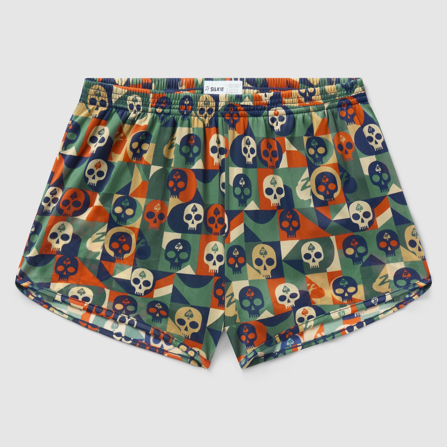 Geo Skulls Silkies featuring a colorful geometric pattern with various skull designs in shades of green, orange, navy, and beige, made from smooth fabric with an elastic waistband.