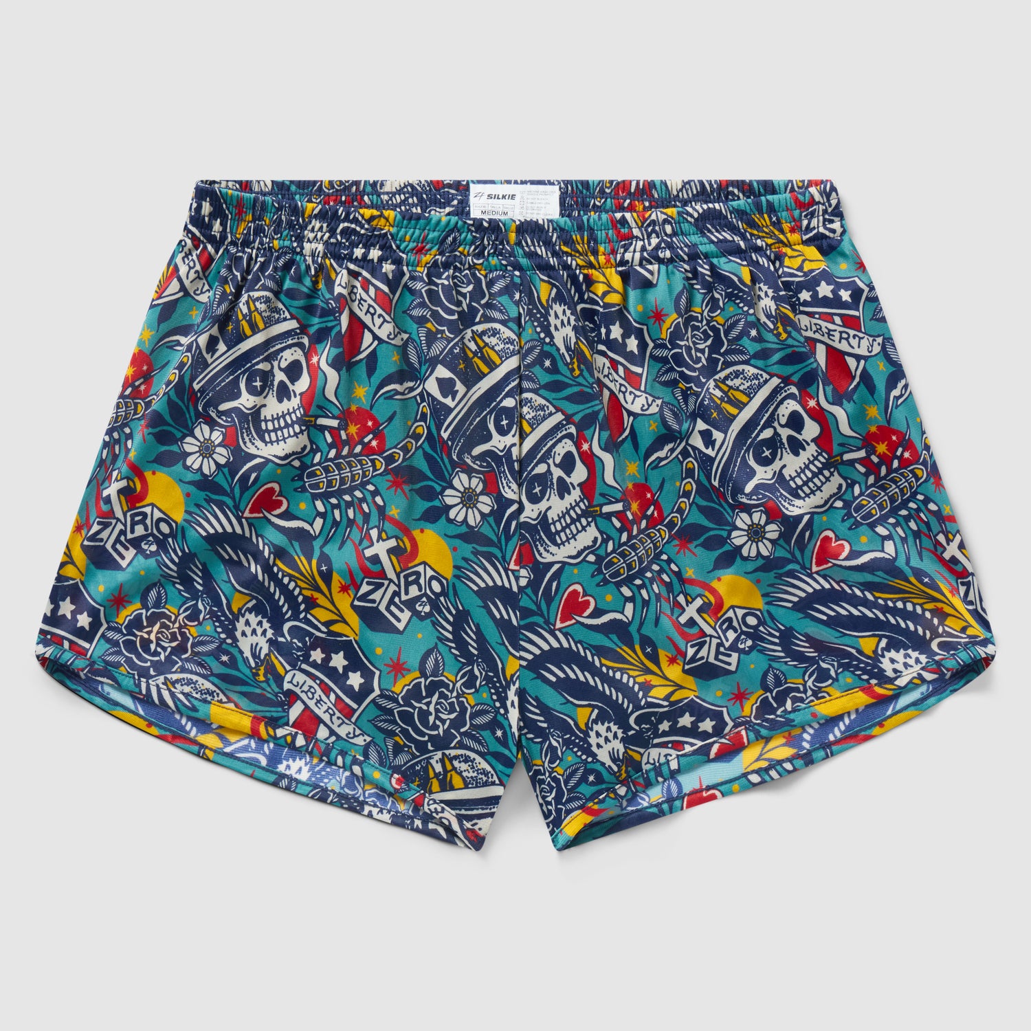 Liberty Skull Silkies boxer shorts featuring a colorful skull and floral tattoo-inspired pattern with stars, hearts, and banner motifs on a vibrant blue background.