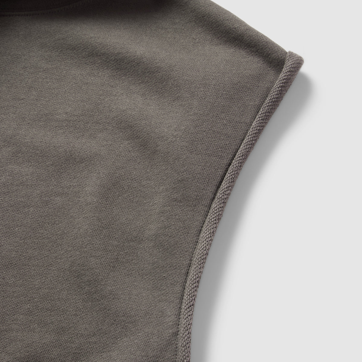 Close-up view of the soft fabric texture and stitching detail on the shoulder of the Smuggler French Terry Muscle Hoodie in a muted gray color.