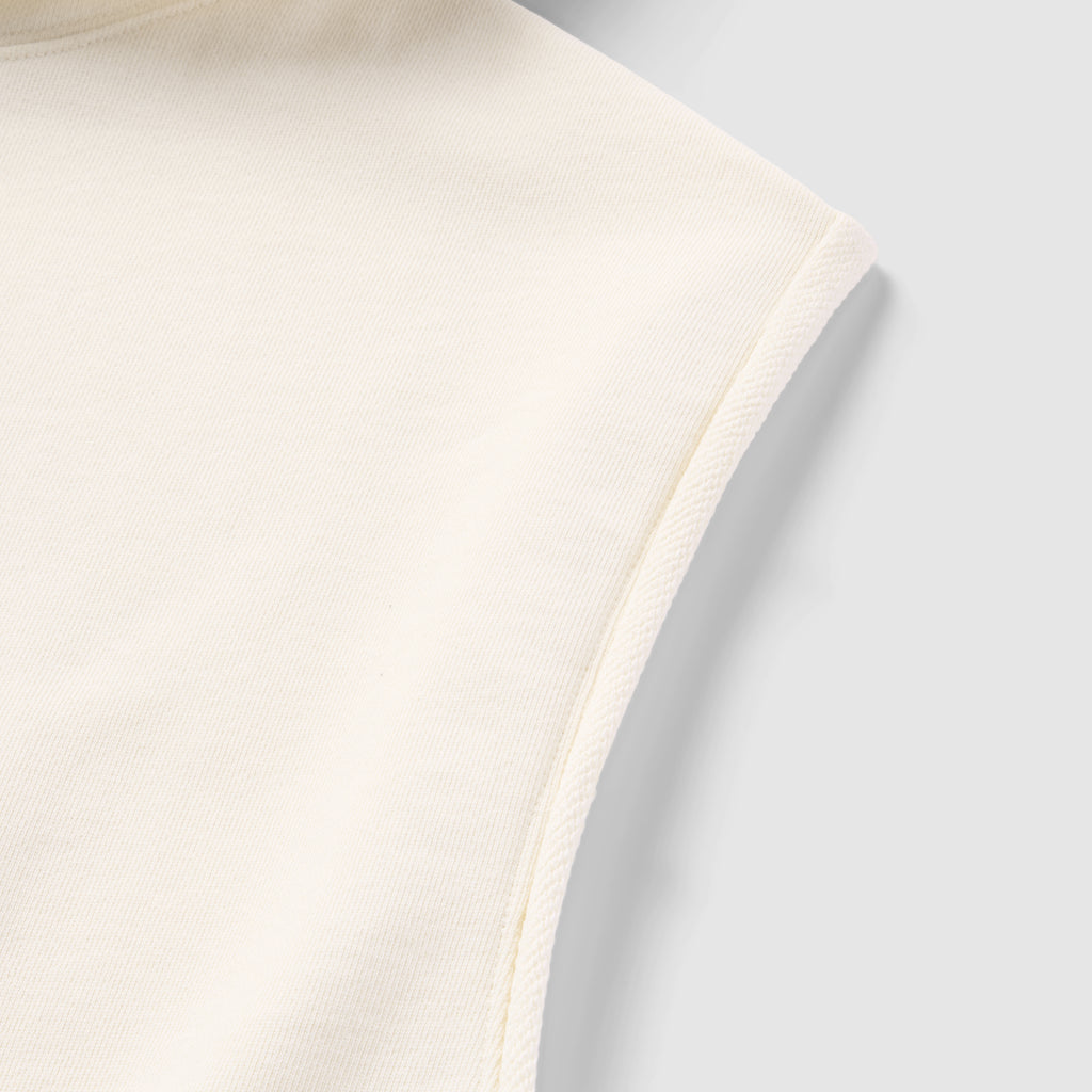 Close-up detail of the light cream fabric and seam on the sleeveless armhole of the Smuggler French Terry Muscle Hoodie.