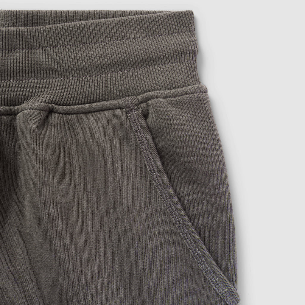 Close-up of a dark gray Smuggler French Terry Jog Shorts - 6" Inseam showing the ribbed waistband and side pocket detail in soft French terry fabric.