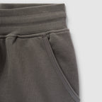 Close-up of a dark gray Smuggler French Terry Jog Shorts - 6" Inseam showing the ribbed waistband and side pocket detail in soft French terry fabric.