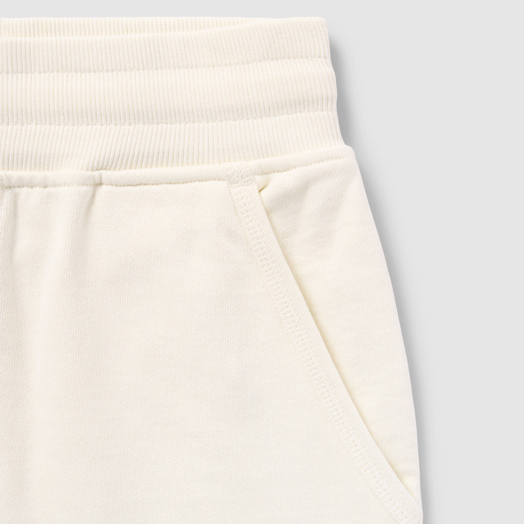 Close-up of cream-colored shorts waistband and pocket detail made from soft fabric showing texture and stitching of Smuggler French Terry Jog Shorts - 6" Inseam.