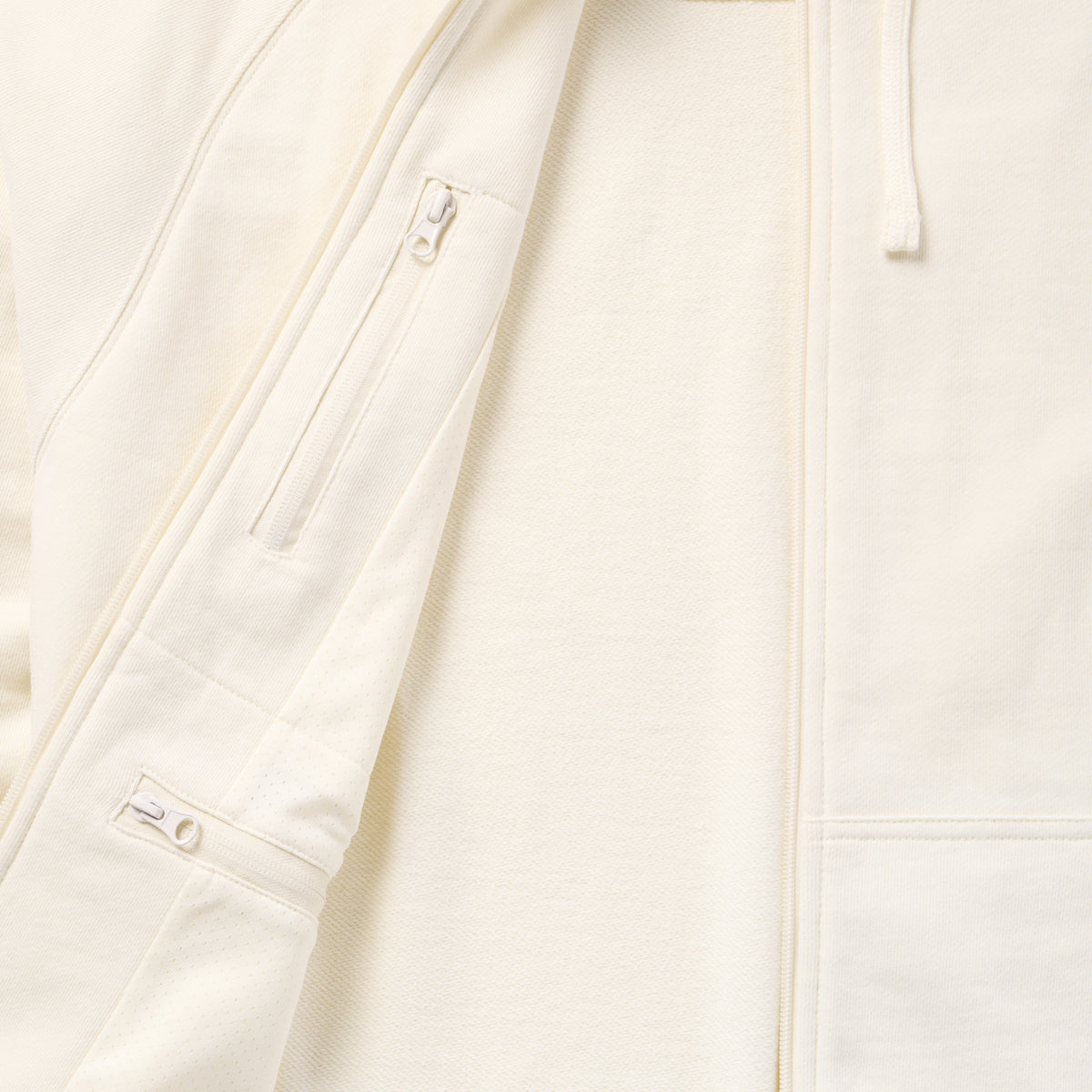 Close-up of the light-colored Smuggler French Terry Zip Hoodie showing the soft fabric texture, full front zipper, and zippered chest pocket detail.