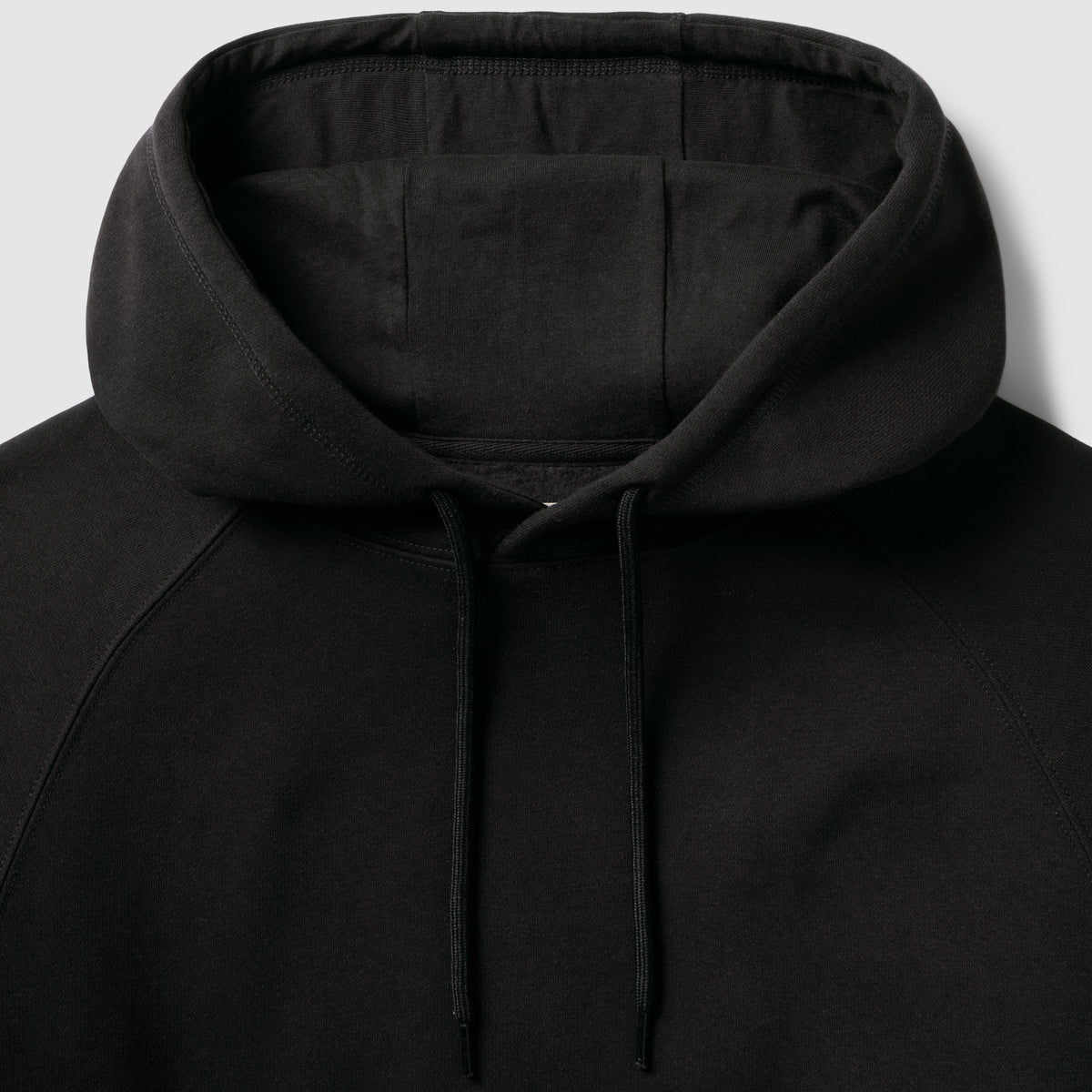 Smuggler Fleece Hoodie in black with a soft lined hood adjustable drawstrings and detailed stitching shown in close up
