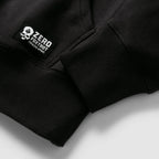 Close up of the black Smuggler Fleece Crew showing its ribbed cuffs and stitched fabric label for a structured outerwear finish