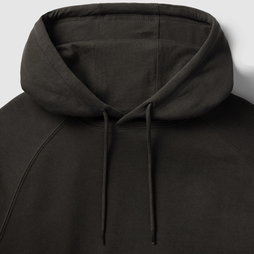 Smuggler Fleece Hoodie in black with a close up view of the hood, drawstrings, raglan seams, and soft fleece texture