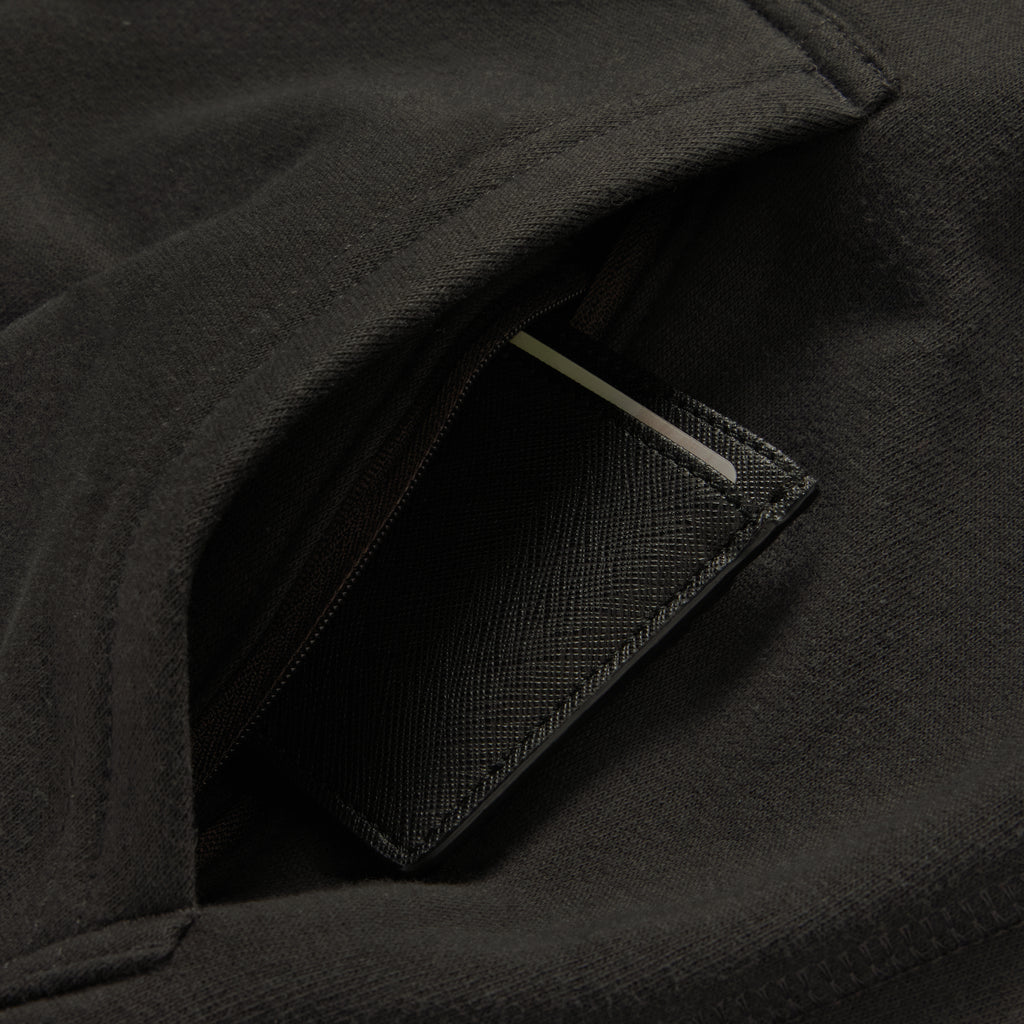 Smuggler Fleece Crew in black with a close up view of the textured fabric and zippered pocket detail with a card partially visible inside