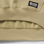 Smuggler Fleece Crew in beige fleece with ribbed hem detailing and a Zero Foxtrot label closeup