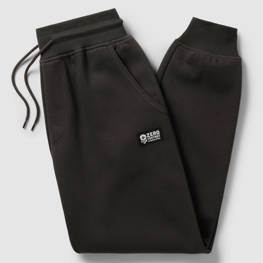 Smuggler Fleece Jogger in black laid flat, featuring an elastic drawstring waistband, side pockets, tapered legs, ribbed cuffs, and a small logo patch