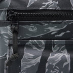 Surplus EDC Sling in black and gray camouflage with a zippered front pocket and adjustable black webbing strap detail