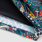 Close-up of colorful Liberty Skull Swim Trunks showing detailed fabric design with skulls, stars, and floral patterns in vibrant red, blue, green, and yellow colors.