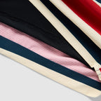 Close-up of the fabric and stitching details on the Old Glory Swim Trunks, featuring layered red, white, blue, and black colors with contrasting textured patterns.