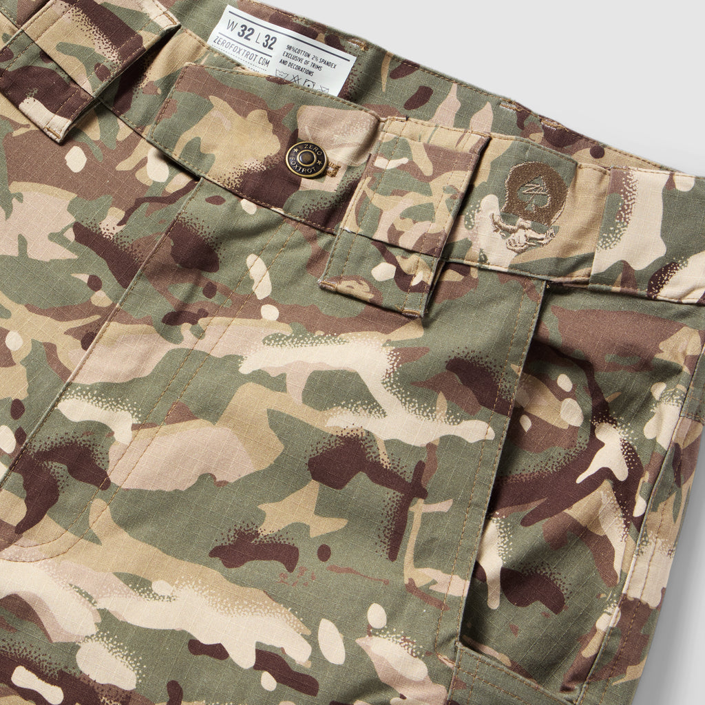 Tac Pants in woodland camouflage with button closure, belt loops, flap cargo pockets, and reinforced stitching shown in close-up.