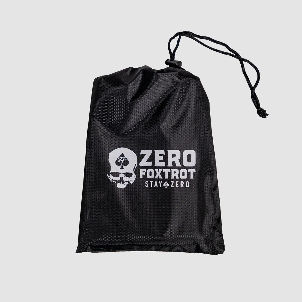 Black mesh drawstring bag with white skull and spade logo and "Zero Foxtrot Stay Zero" text, designed to hold the Microfiber Beach Towel (2025).