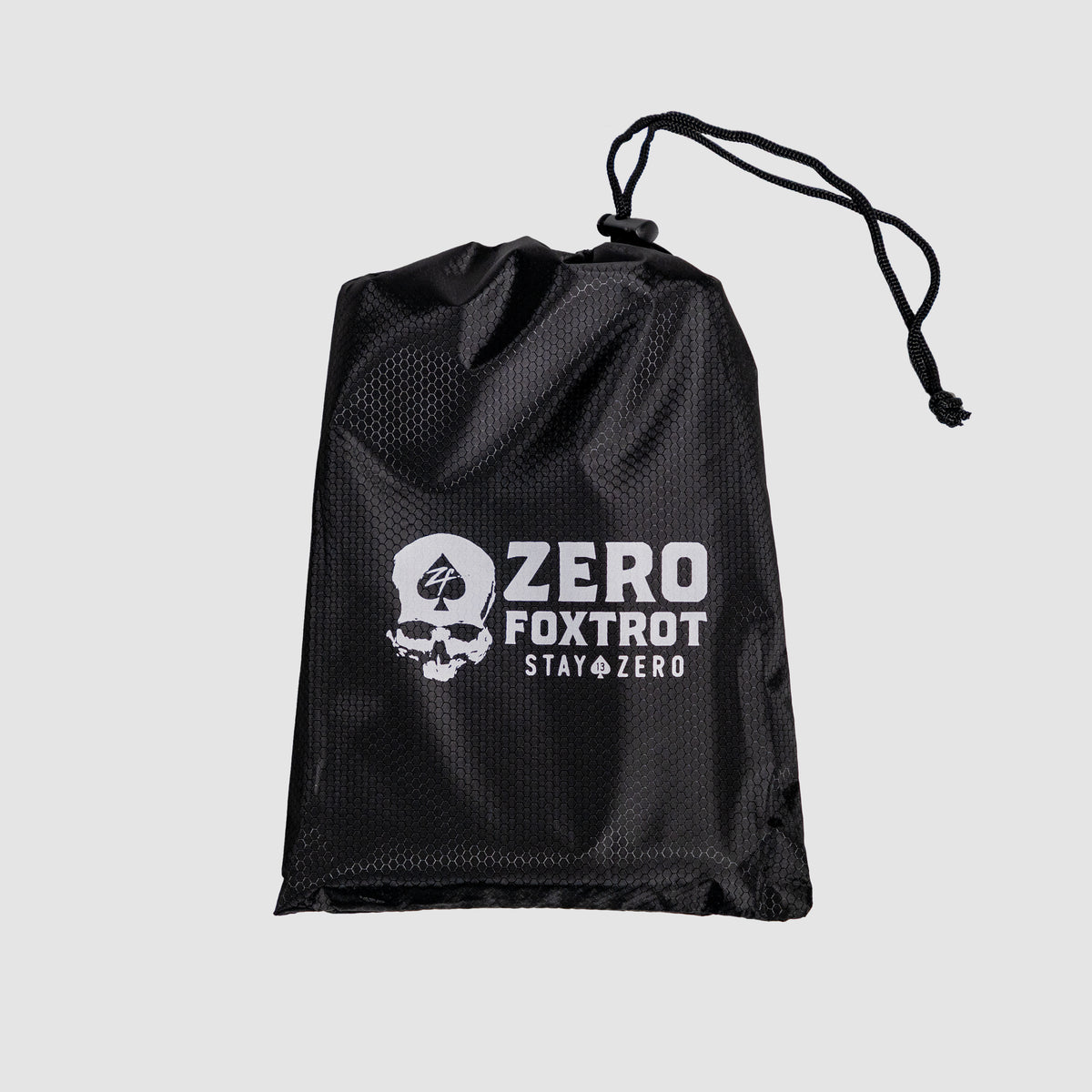 Black mesh drawstring bag with white skull and spade logo and "Zero Foxtrot Stay Zero" text, designed to hold the Microfiber Beach Towel (2025).