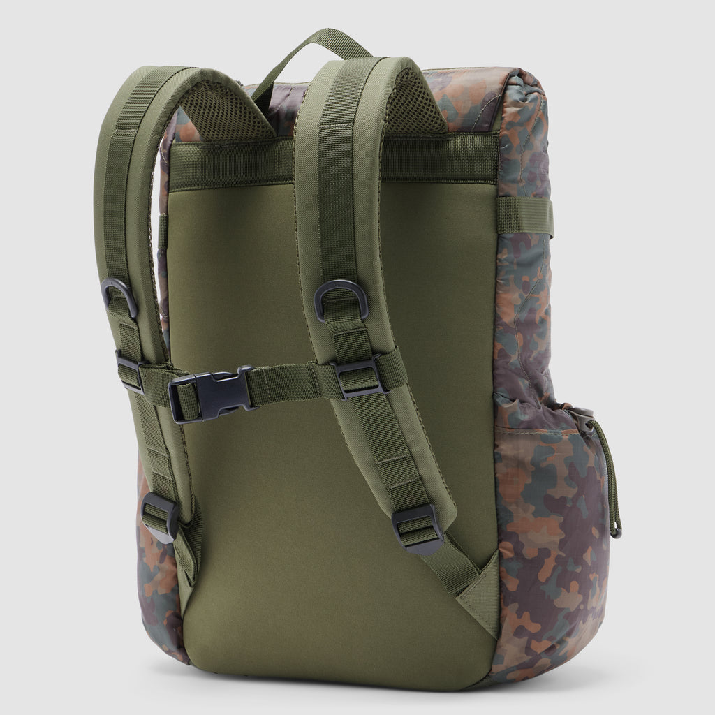 Woobie Backpack shown from the back with adjustable padded shoulder straps, a chest buckle, and a camouflage patterned fabric on the sides and top.