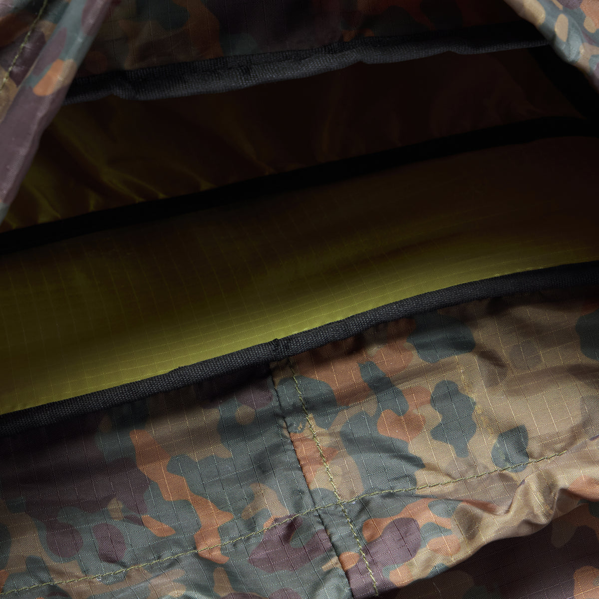 Interior view of a Woobie Backpack showing durable camouflage-patterned fabric and a padded compartment for secure storage.