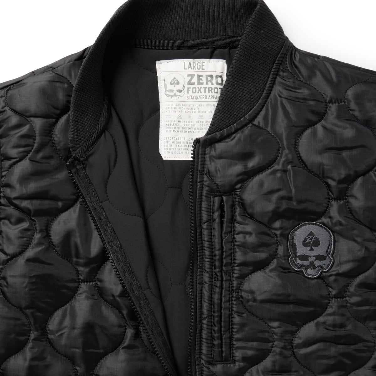 Woobie Vest (Last Chance), black quilted vest close-up with ribbed collar, front zipper, chest pocket, skull patch, and interior size label