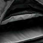 Close-up view of the interior compartment of the Woobie Backpack showing a light-colored padded laptop sleeve and spacious storage area lined with durable fabric.