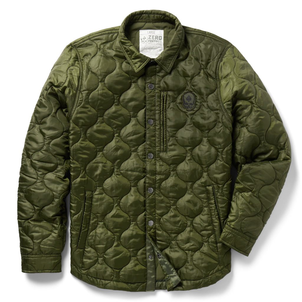 Woobie Shacket in olive green with quilted texture, button front, shirt collar, long sleeves, chest emblem, and front pockets on a white background