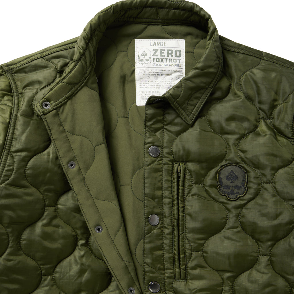 Woobie Shacket in olive green with quilted texture snap button front collar chest patch and interior label shown in close up