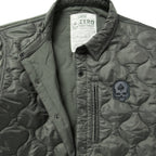 Woobie Shacket in olive gray quilted fabric with a collared snap front, zip chest pocket, and skull patch detail shown close up.