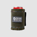 Rations Drink Wrap in camouflage fabric and olive green fleece with a patch reading "Zero Foxtrot," designed to insulate and grip a standard beverage can.