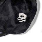 Close-up of black fabric with a white skull wearing a cap featuring a spade symbol, printed on ZF Silkies - Camos shorts.