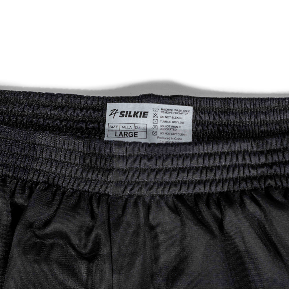 Close-up of the elastic waistband and care label on ZF Silkies - Camos in black, showing size large and washing instructions printed on the tag.