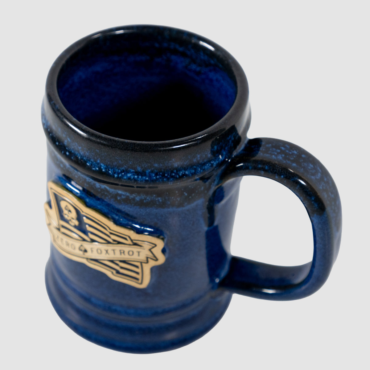 Ceramic blue USA Flag Stein with a sturdy handle and a gold and black flag emblem on the side, featuring a glossy finish and a classic stein shape.