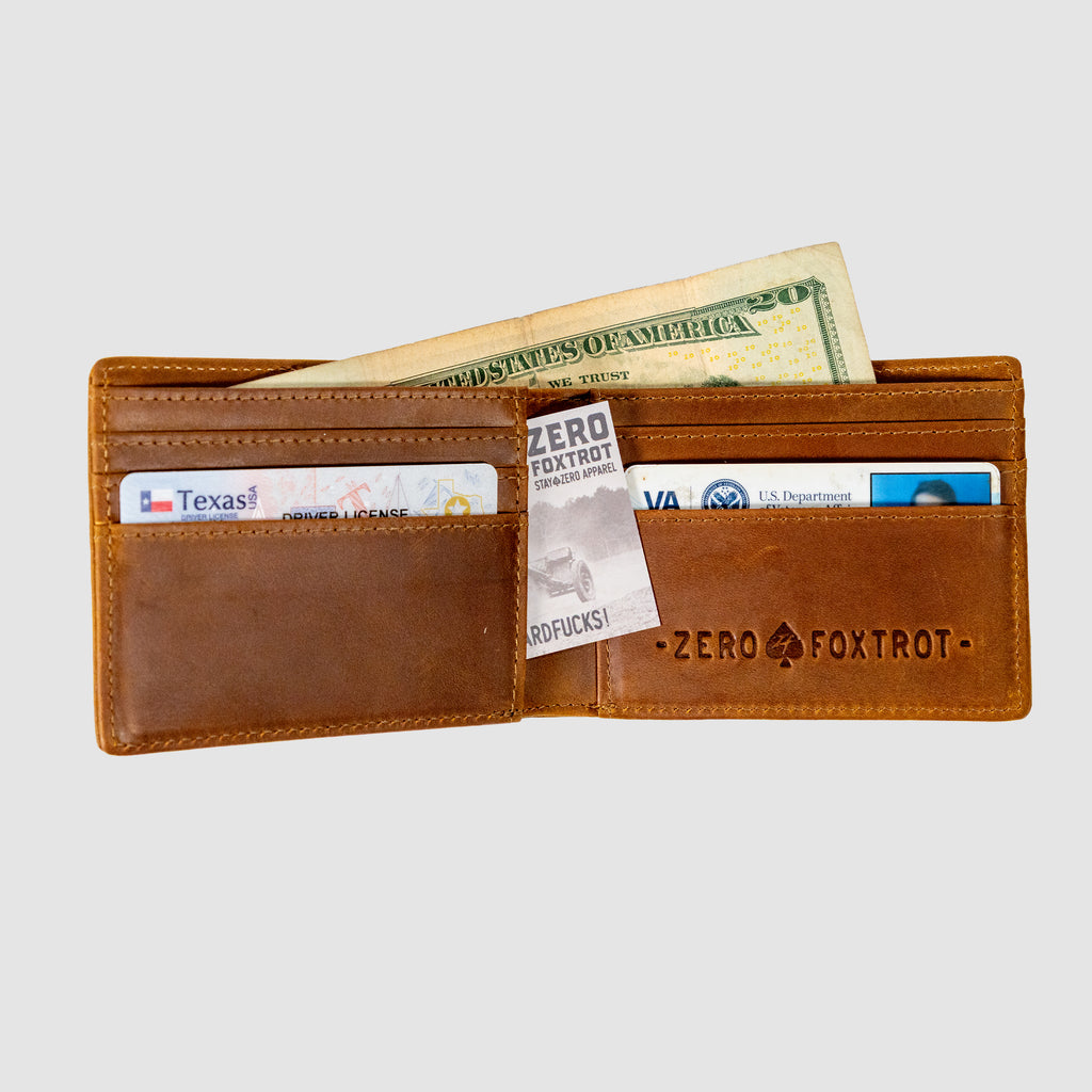 Smuggler Leather Wallet open to show brown leather interior with multiple card slots, a U.S. twenty-dollar bill, and several cards including a Texas driver’s license and a VA identification card.