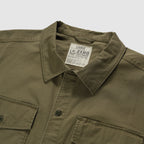 Close-up view of an olive green CPO Shirt showing the collar, front buttons, and chest pockets on a flat surface.