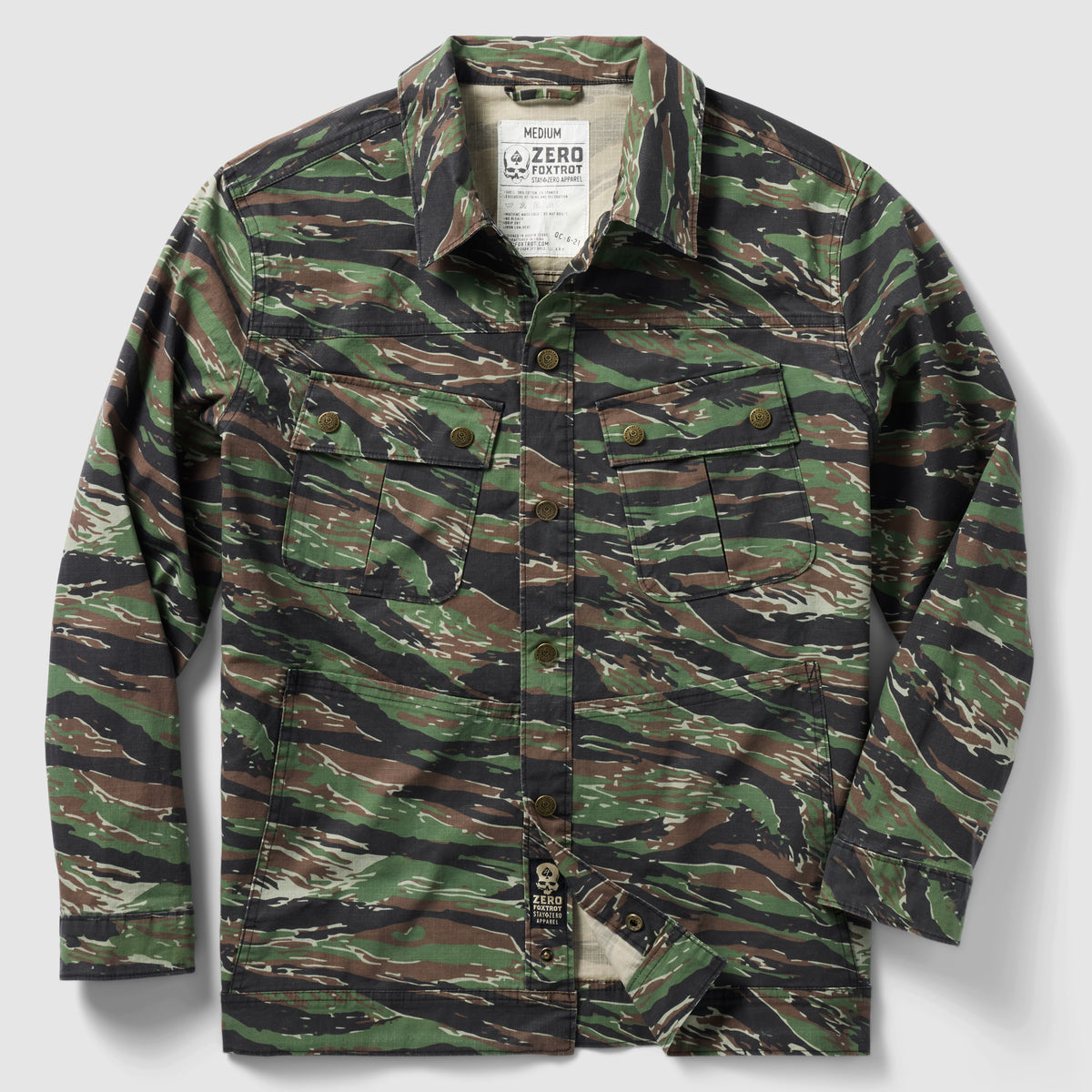 Chore Jacket in green and brown tiger stripe camouflage pattern with button-front closure and multiple chest pockets laid flat against a white background.