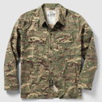 Chore Jacket in camouflage pattern featuring a button-up front, two chest flap pockets with buttons, and two side hand pockets, designed for durable outdoor wear.