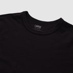 Black cotton skivvy tee with a classic round neckline, soft texture, and subtle slub fabric detail, shown in a large size.
