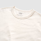 Close-up view of a light bone-colored Cotton Skivvy Tee featuring a round neckline and soft, textured cotton fabric in size large.